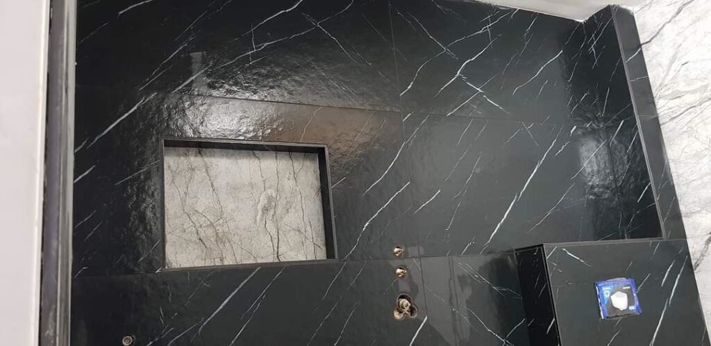 Zwarte marmerlook wand met verlichte inbouwnis