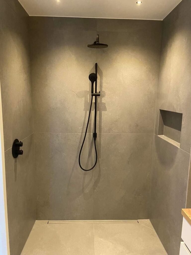 Douche met zwarte regendouche en inbouwnis in beige wandafwerking