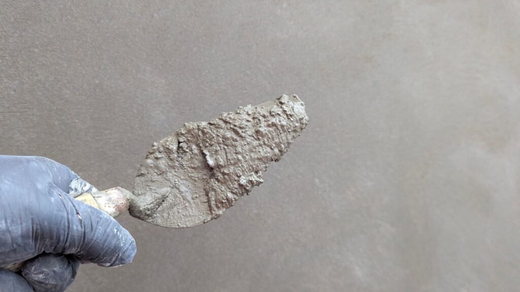 Stukadoor brengt stucwerk aan op een muur met een truweel