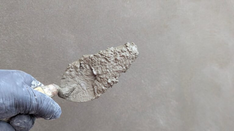 Stukadoor brengt stucwerk aan op een muur met een truweel